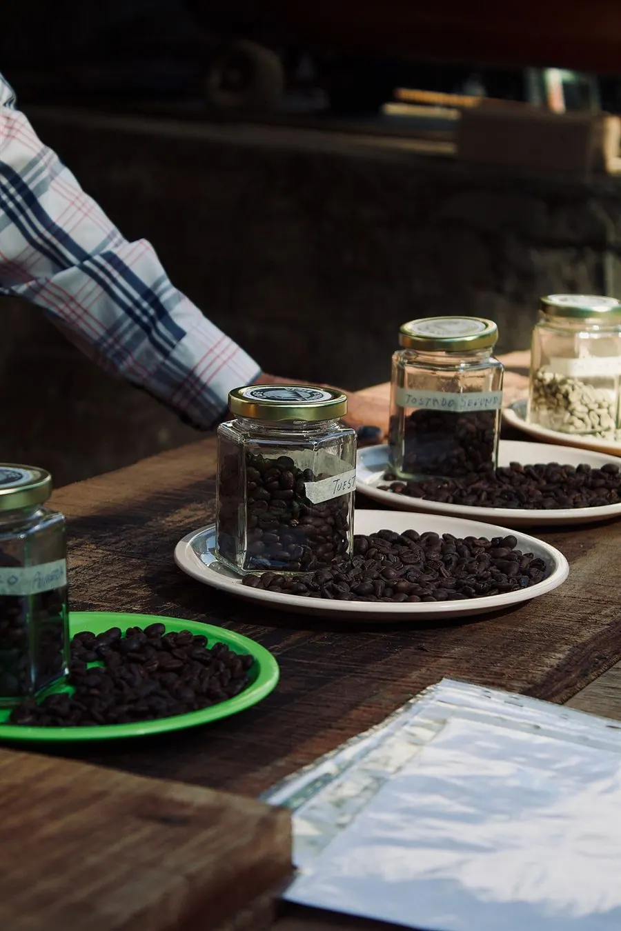 Frascos etiquetados con granos de café sobre una mesa