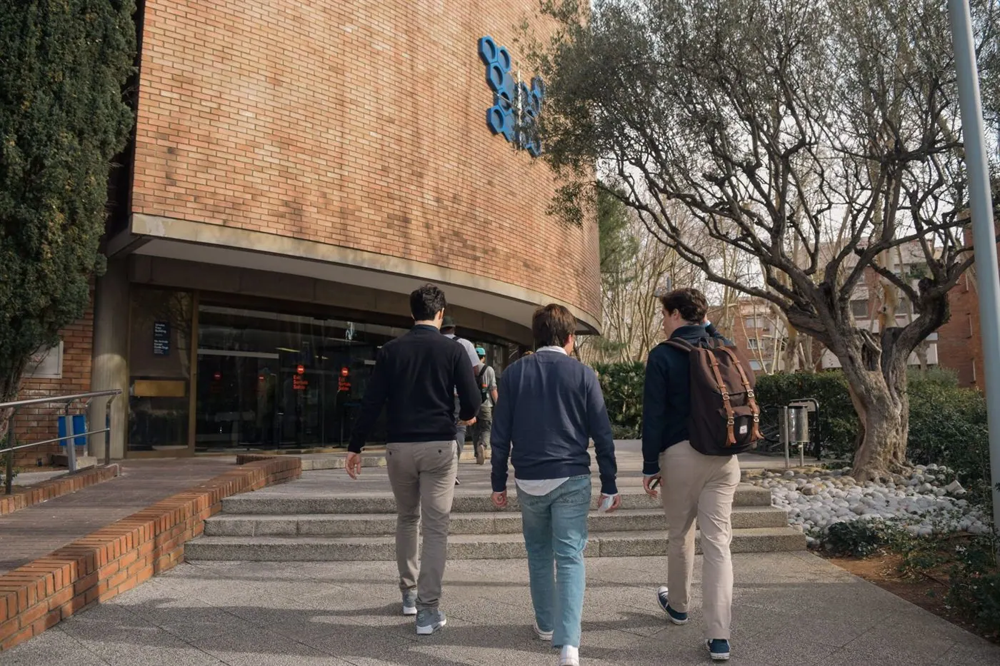 Estudiantes entrando a un edificio universitario