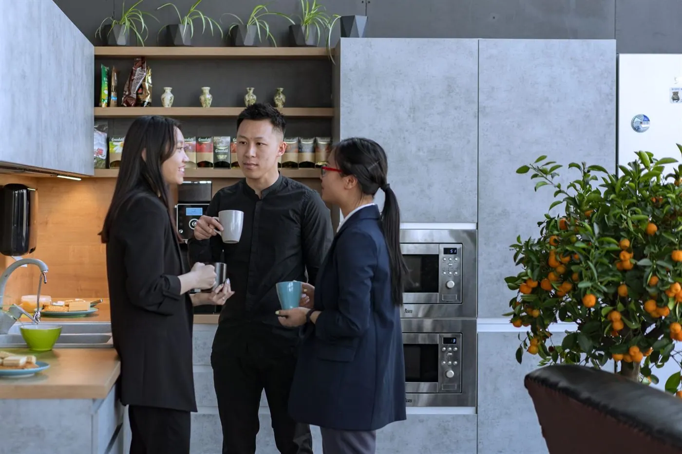 Personas conversando durante una pausa en una cocina de oficina